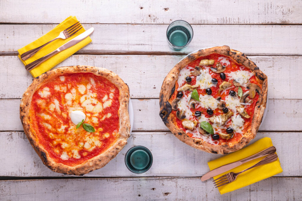 Pizza fatta in casa servita su piatti grandi apparecchiati con stile